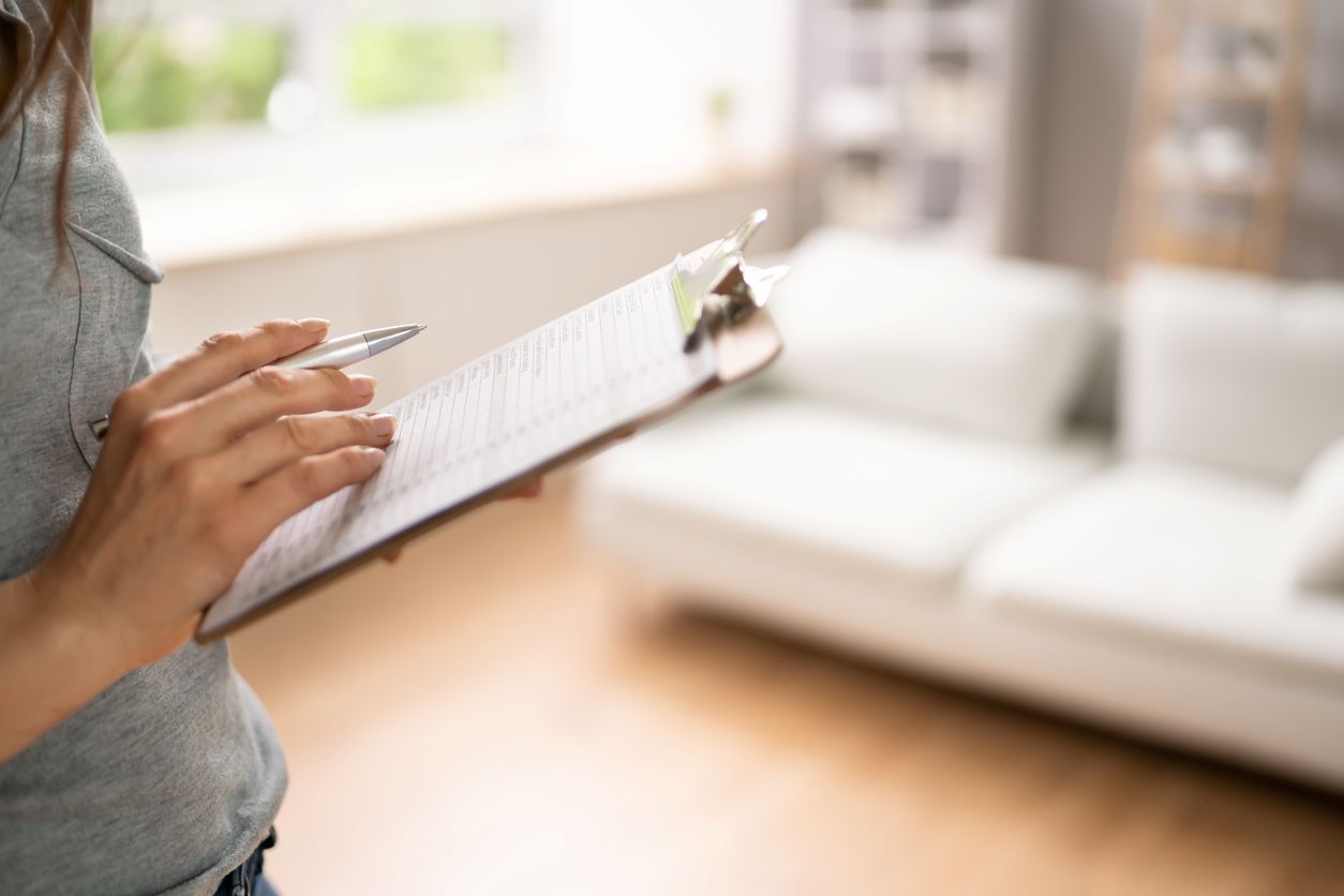 A woman holds a checklist with questions to ask when touring an apartment.