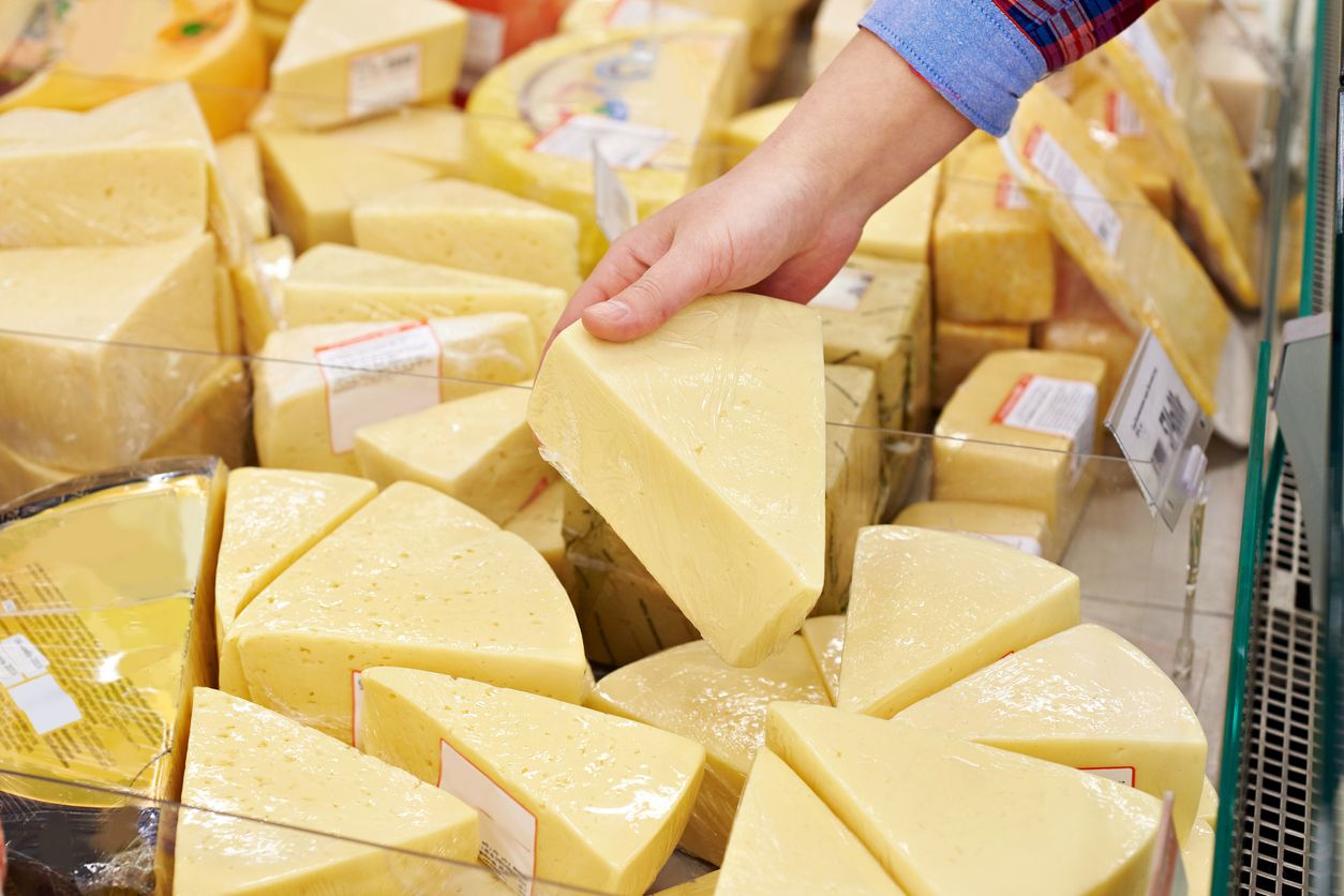 A shopper inspects gourmet cheeses.