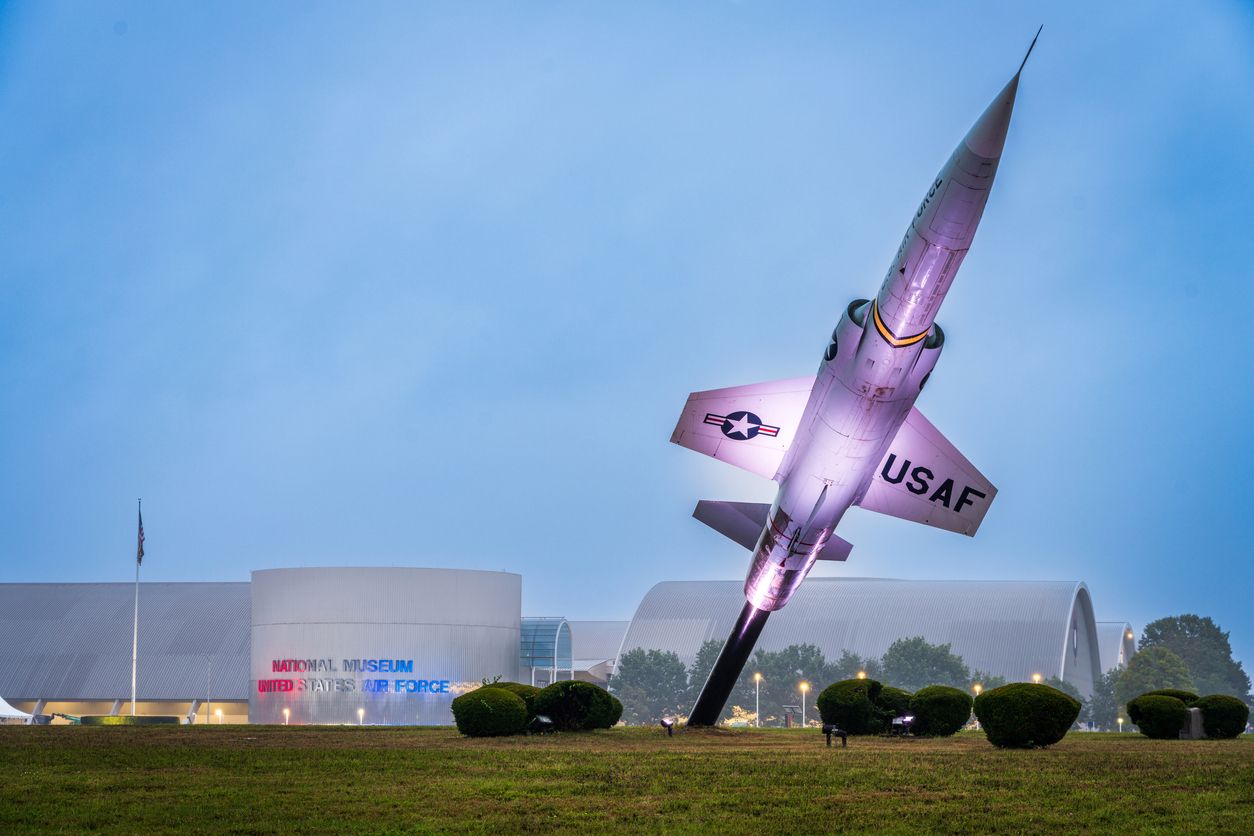 The exterior of the National Museum of the United States Air Force in Dayton, OH, with a darkening blue sky.
