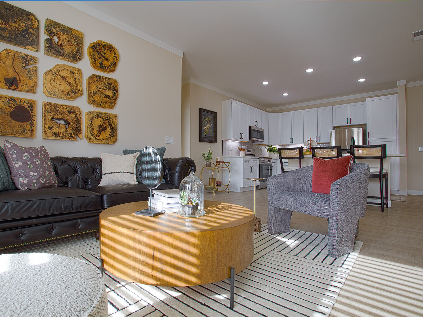 Bright living room at Relay 129 in Liberty Township featuring open-concept layout, large windows, modern finishes, and seamless flow into the kitchen with matte black hardware accents.