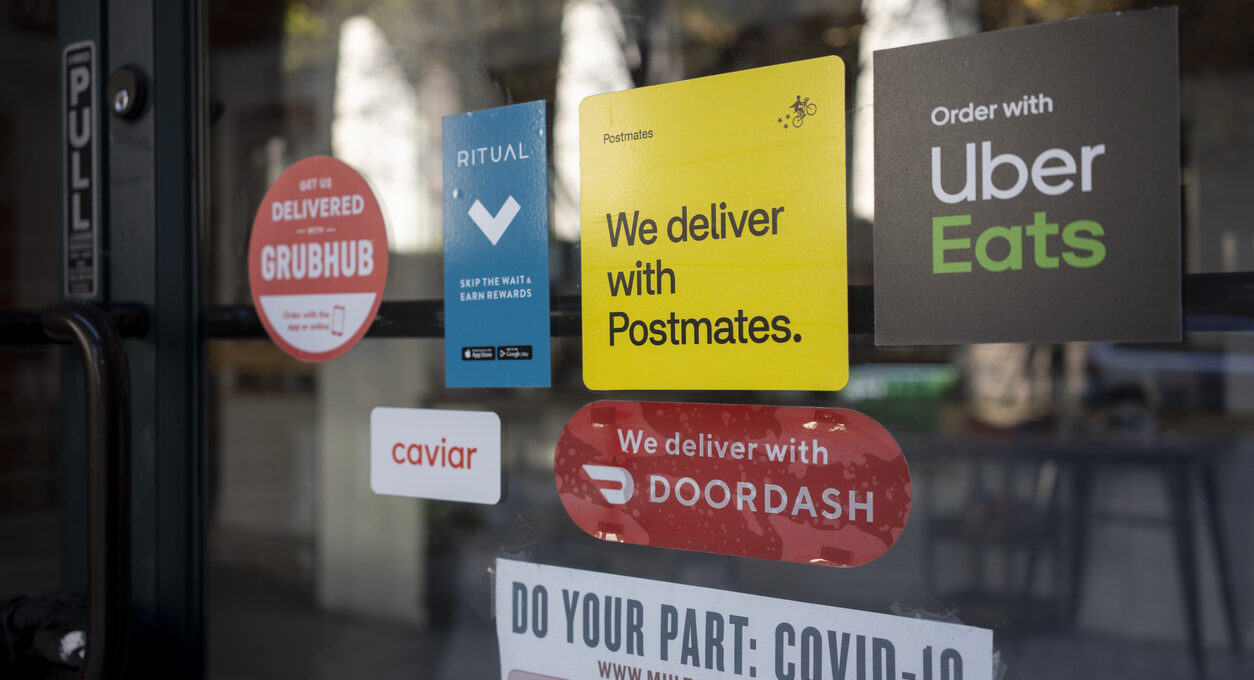 A door covered with various food delivery service stickers