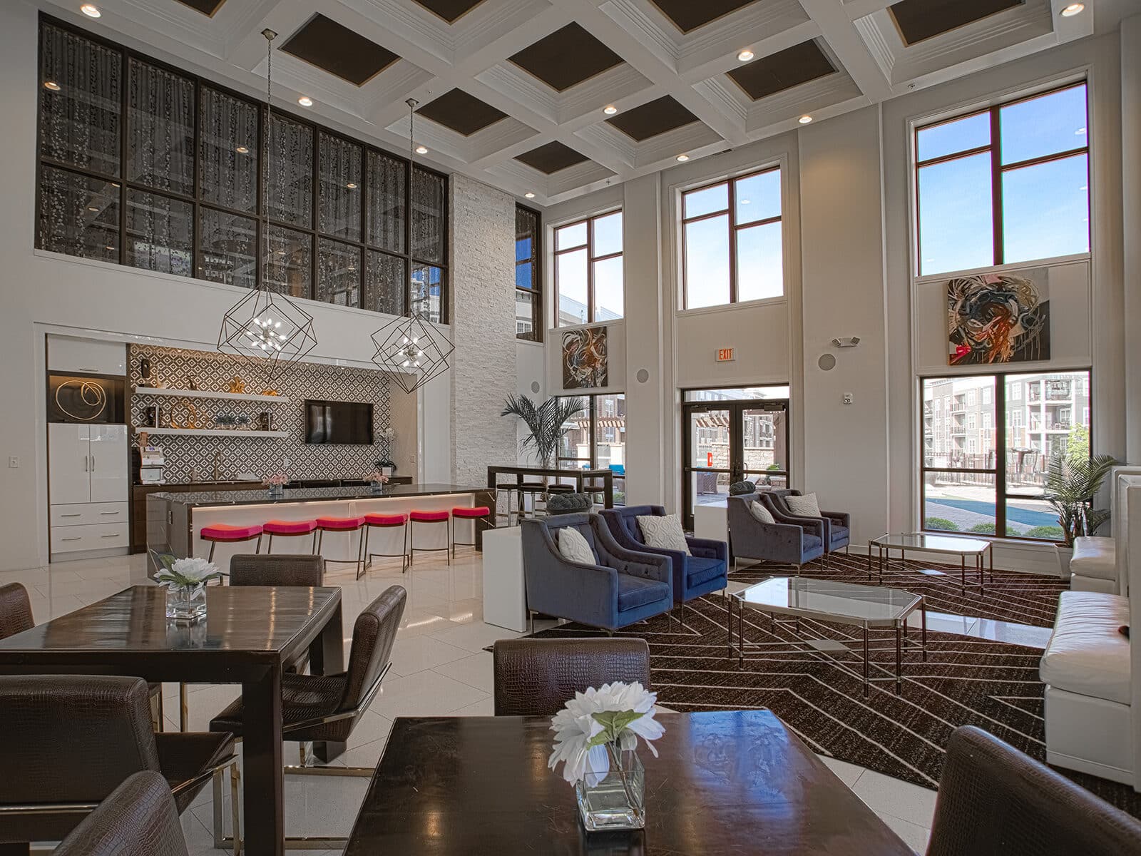 Stylish resident clubhouse at Allure Apartments with modern bar seating, geometric pendant lights, lounge areas, and entertainment spaces.