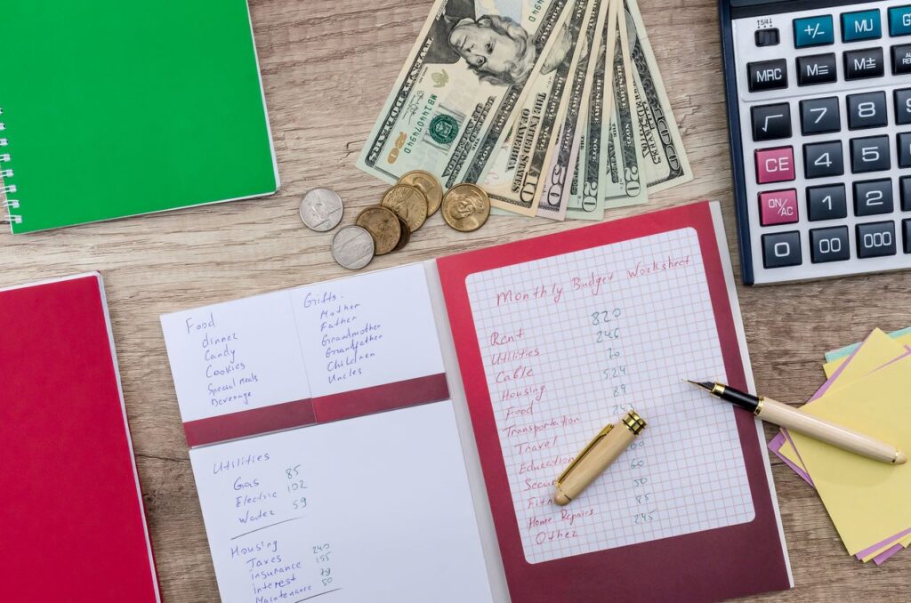 A collection of notebooks and dollar bills as someone organizes their finances.