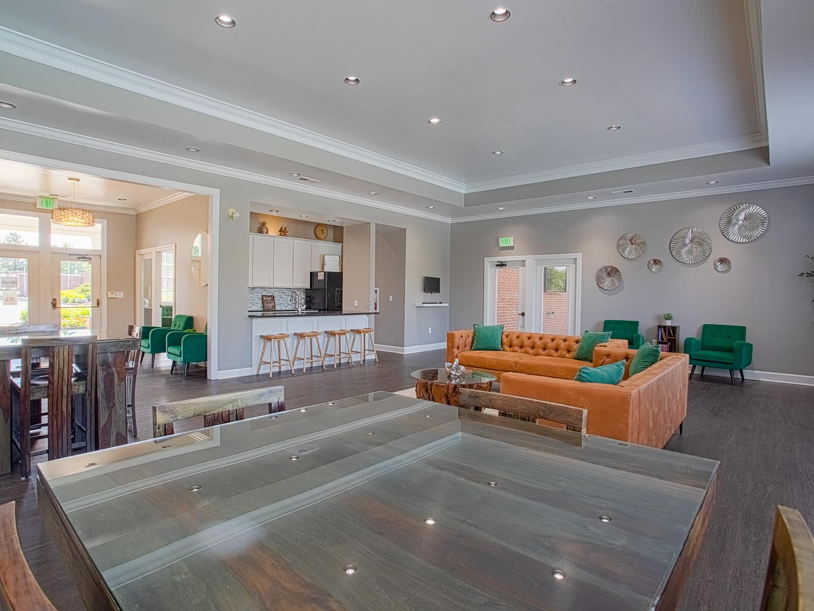Open-concept resident clubhouse at Emerald Lakes in Greenwood, Indiana, featuring modern lounge seating, high-top dining tables, recessed lighting, and contemporary community gathering spaces by HILLS Properties.