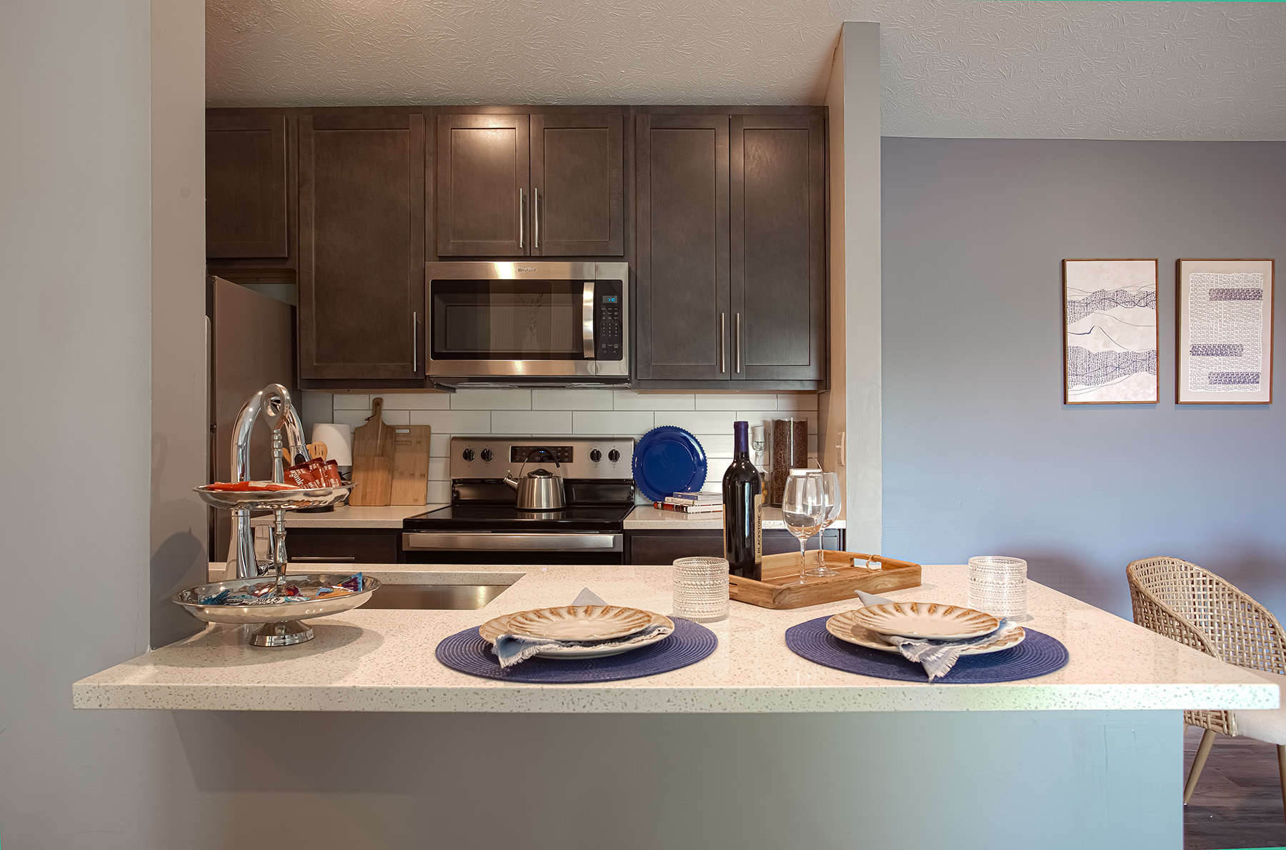 Modern galley-style kitchen featuring quartz countertops, stainless steel appliances, contemporary cabinetry, and ample storage space.