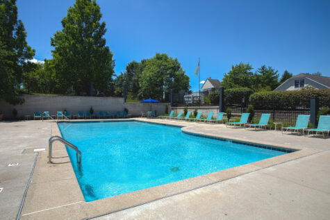 Resort-style swimming pool at Island Club Apartments in Deerfield Township, Ohio, surrounded by lounge seating and beautifully maintained landscaping.