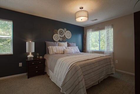 Large primary bedroom at Island Club Apartments featuring plush carpeting, neutral finishes, and ample space for bedroom furnishings.