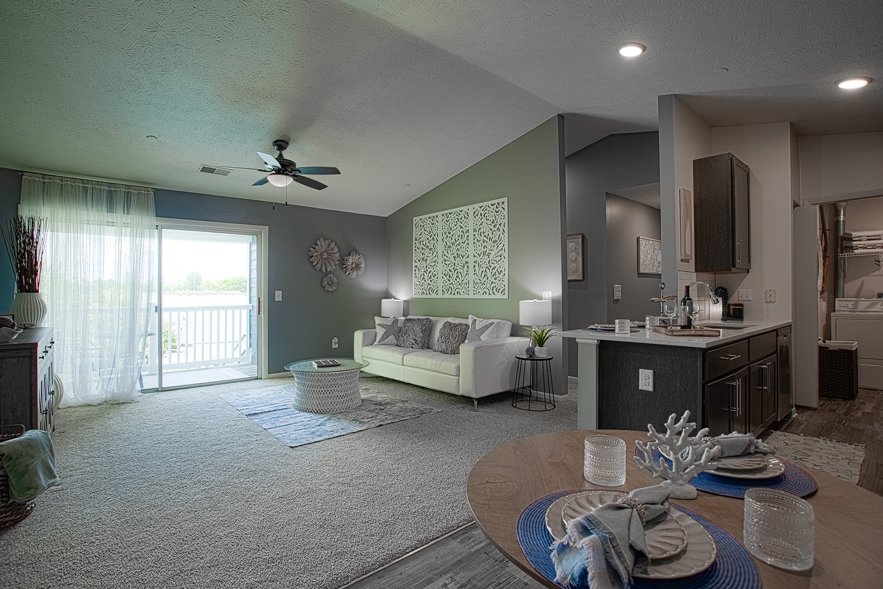Open kitchen layout featuring quartz countertops, stainless steel appliances, and seamless flow into the living and dining areas.