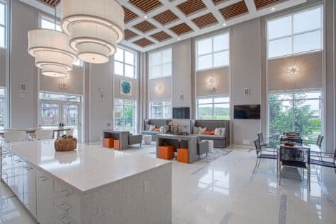 Elegant apartment community gathering space at Savoy at the Streets of West Chester in West Chester, Ohio, with floor-to-ceiling windows, contemporary seating areas, upscale finishes, and a modern resident lounge by HILLS Properties.