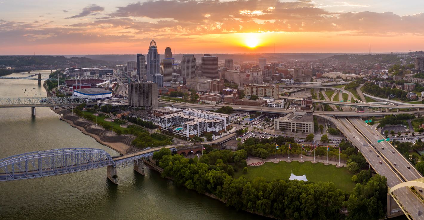 Cincinnati in the state of Ohio, with brightly illuminated high skyscraper buildings in the downtown district. American megapolis with a business financial district at sunset.