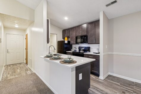 Open-concept kitchen and living area in the Hunter floor plan featuring quartz countertops, modern cabinetry, and ample living space.