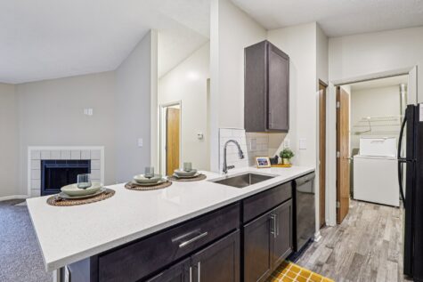 Large breakfast bar with quartz countertops overlooking the living room and fireplace in the Hunter floor plan.