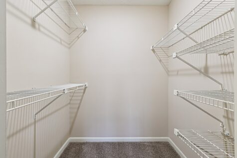 Spacious walk-in closet with multiple wire shelving systems providing ample storage and organization space.
