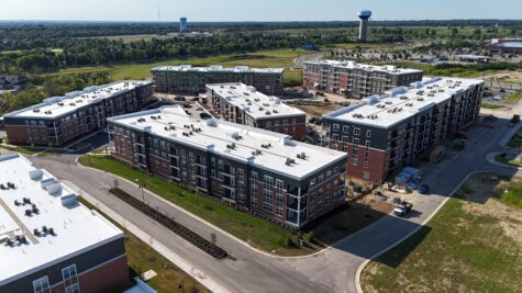 Drone view of Relay 129 Apartments and Townhomes in Liberty Township, Ohio, featuring contemporary apartment buildings, landscaped streets, and the surrounding Liberty Center area.