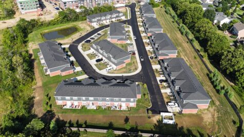 Aerial view of the townhome neighborhood at Relay 129 Apartments and Townhomes in Liberty Township, Ohio, showcasing attached garages, private entrances, and beautifully landscaped streets.