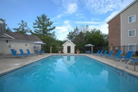 Sparkling swimming pool at Fox Chase South Apartments in Southgate, Kentucky, surrounded by lounge seating and beautifully maintained community grounds.