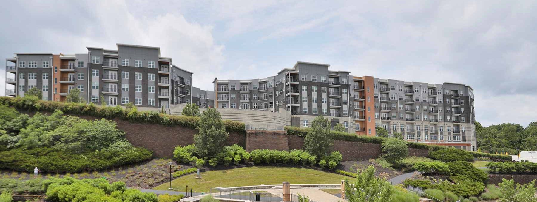 Exterior view of Vantage at Anderson Towne Center luxury apartments in Cincinnati, OH, overlooking a landscaped waterfront area.