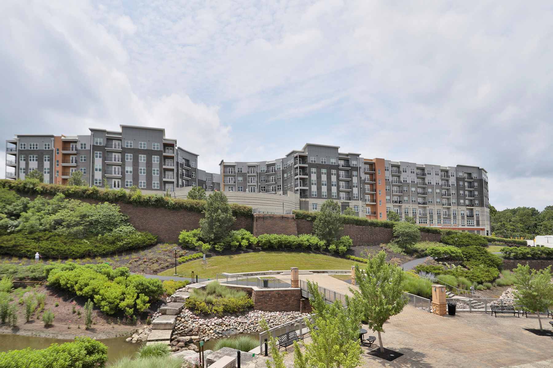 Exterior view of Vantage at Anderson Towne Center luxury apartments in Cincinnati, OH, overlooking a landscaped waterfront area.