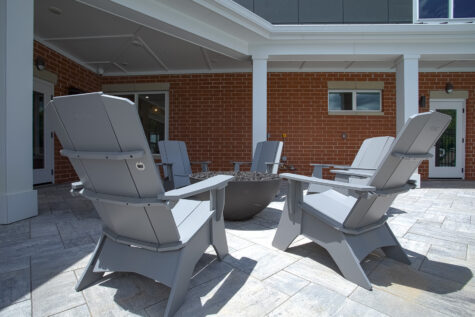 Modern outdoor social deck with fire pit at Relay 129 Apartments and Townhomes featuring pergola-covered seating, contemporary furnishings, and resort-inspired amenities.