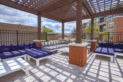 Modern outdoor social deck at Relay 129 Apartments and Townhomes featuring pergola-covered seating, contemporary furnishings, and resort-inspired amenities.