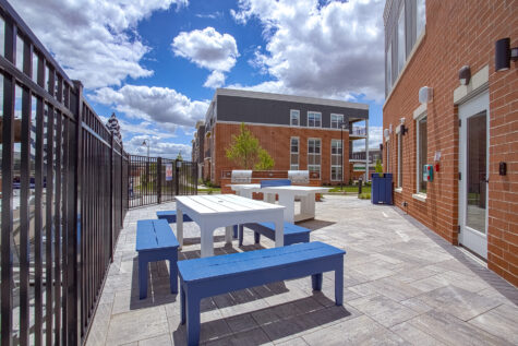 Inviting outdoor lounge area beneath a pergola at Relay 129 Apartments and Townhomes, featuring comfortable seating and a relaxing space for residents to gather.