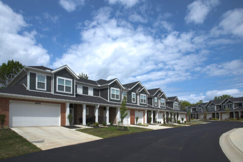 Luxury townhomes at Relay 129 Apartments and Townhomes in Liberty Township, Ohio, showcasing attached two-car garages, contemporary architecture, and beautifully maintained community landscaping.
