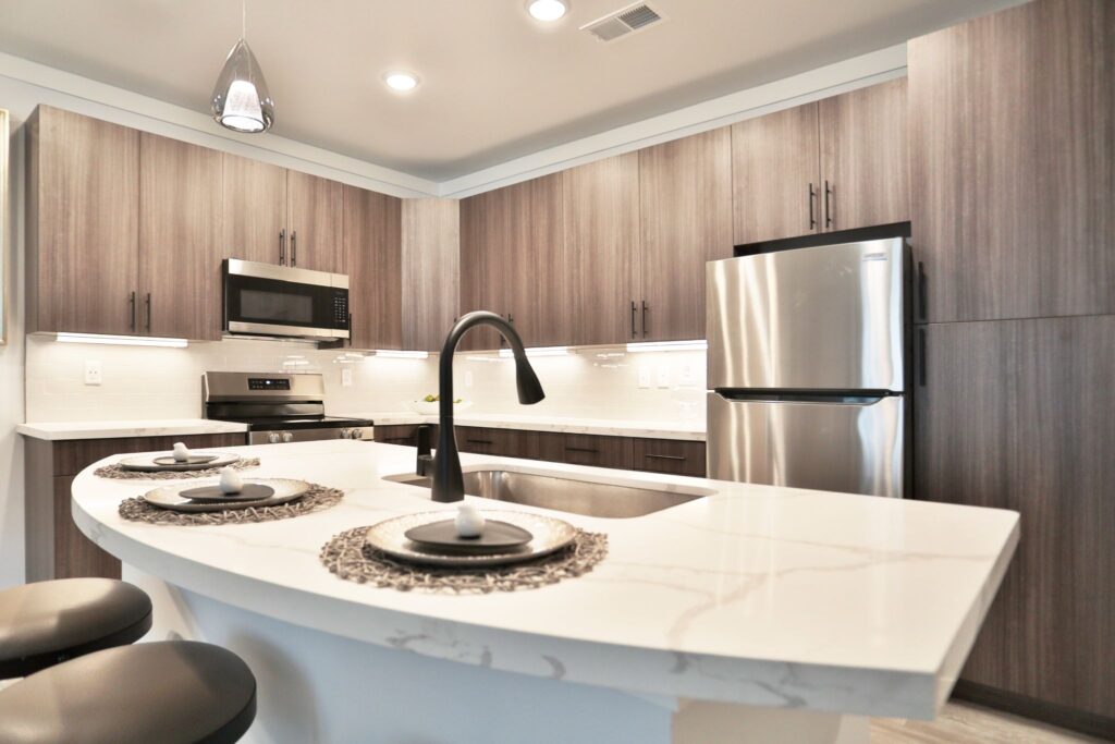 A sleek modern kitchen with quartz countertops and stainless steel appliances.
